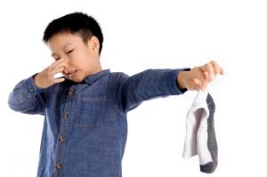 Little boy holding a stinky sock