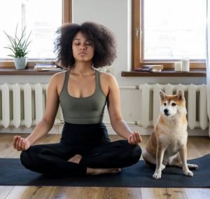 Woman meditating with her dog