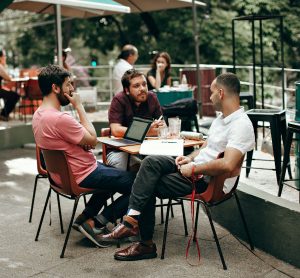 Three men talking around a table